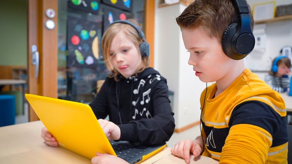 basisschool leerlingen werken in tweetallen samen aan een opdracht voor digitale geletterdheid